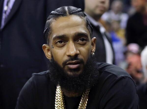 图片 - 说唱歌手尼普西·哈塞尔 (Nipsey Hussle) 出席 在加利福尼亚州奥克兰举行的金州勇士队 (Golden State Warriors) 与密尔沃基雄鹿队 (Milwaukee Bucks) 之间的 NBA 篮球比赛。三年前，说唱歌手哈塞尔 (Nipsey Hussle) 在洛杉矶一家服装店外被枪杀，这家服装店是他为振兴洛杉矶而创立的。在他长大的社区，对被控杀害他的男子的审判最终将于 星期三开始。 （美国头条网照片/马西奥·何塞·桑切斯，档案）